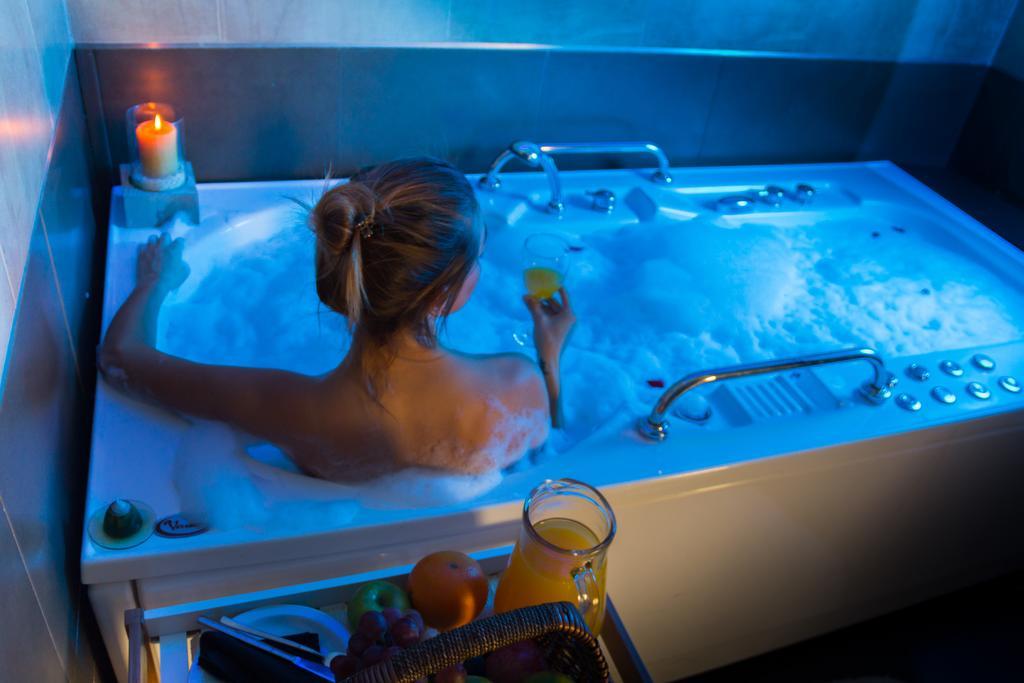 하워드 존슨 플라자 리조트 앤 카지노 마요라즈고 파라나 외부 사진 A woman in a whirlpool bathtub